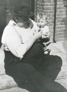 876458 Portret van caféhouder Marinus Johannes de Winter ('Dikke Dries', 1901-1952), die z'n kleinzoon Ries een pijp ...